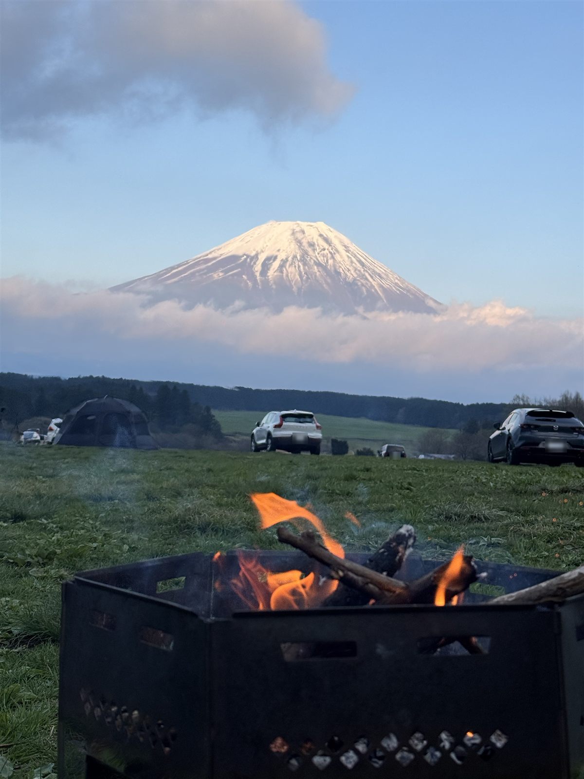 夕方の焚き火と、雪をかぶった富士山。